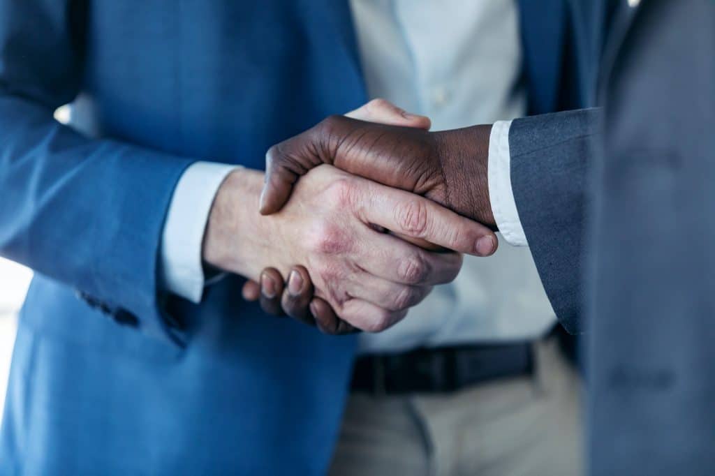Close-up view of business partner handshaking process.