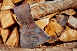 Close up of axe agains firewood background
