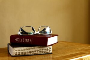 Holy Bibles and eyeglasses on a table